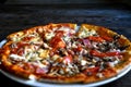 Pizza with cheese, bacon, tomato and herbs in a white bowl on a background of old boards. Royalty Free Stock Photo