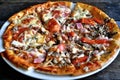 Pizza with cheese, bacon, tomato and herbs in a white bowl on a background of old boards. Royalty Free Stock Photo