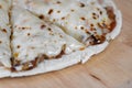 Pizza and cheese on wooden plate on table Royalty Free Stock Photo