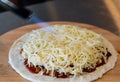 Pizza and cheese on wooden plate on table Royalty Free Stock Photo