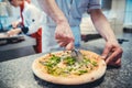 Pizza chef cutting his creation which is soon to be served Royalty Free Stock Photo