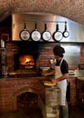 Pizza Chef put the pizza inside the Wood Oven Royalty Free Stock Photo