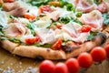 Pizza with cherry tomatoes, prosciutto and ruccola