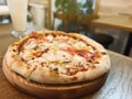 Pizza with chicken, tomatoes, corn and mozzarella is on the table in a plate. Restaurant food. selective focus Royalty Free Stock Photo