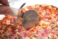pizza cutter on italian pizza margarita in a white plate Royalty Free Stock Photo