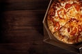 Pizza in the in delivery box on the wood Royalty Free Stock Photo