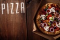 Pizza in the in delivery box on the wood Royalty Free Stock Photo