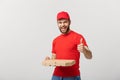 Pizza delivery concept. Young handsome delivery man showing pizza box and holding thumb up sign. Isolated on white Royalty Free Stock Photo