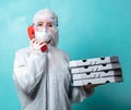 Pizza delivery girl with boxes in protective suit on blue background