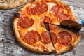 Pizza with different toppings. Italian pizza with different sorts of cheese, vegetables and meat on old wooden background close up Royalty Free Stock Photo