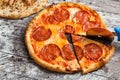 Pizza with different toppings. Italian pizza with different sorts of cheese, vegetables and meat on old wooden background close up Royalty Free Stock Photo