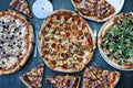 Pizza dinner. Flat lay of various types of Italian pizza on rustic table, top view. Quick lunch, celebration, meeting concept