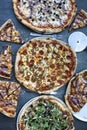 Pizza dinner. Flat lay of various types of Italian pizza on rustic table, top view. Quick lunch, celebration, meeting concept.