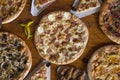 Pizza dinner. Flat of various kinds of Italian pizza on rustic wooden table, top view. Quick lunch, celebration, meeting concept