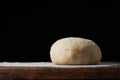 Pizza dough or baking on a dark black background of wood. Baking bread, pizza, pasta. Recipe from chef cooks pizza. Italian home c