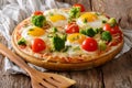 Pizza with eggs, cheese, broccoli, tomatoes and herbs close-up. Royalty Free Stock Photo