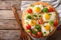 Pizza with eggs, cheese, broccoli, tomatoes and herbs close-up.