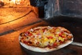 Pizza in firewood oven with flame behind Royalty Free Stock Photo