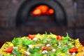 Pizza in front of stone stove with fire. Pizzeria background.