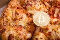 Pizza and golden physical bitcoin, concept of buying pizza with bitcoin