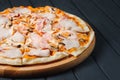 Pizza on gray wood background, side view, close up.