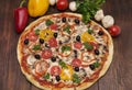 Pizza with ham, pepper and olives. Delicious italian pizzas on a wooden background Royalty Free Stock Photo