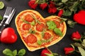 Pizza Heart shaped margherita with tomatoes and mozzarella vegetarian. Food concept of romantic love pizza for Valentines Day