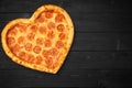 Pizza heart for Valentine`s Day romantic concept copy space on rustic dark black background. Top View. Flat lay