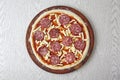 Pizza ingredients, pizza dough with tomato sauce and mozzarella cheese on wooden board on gray background. top view