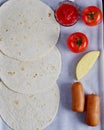 pizza ingredients are on the table, tomatoes, ketchup, sausages and pita bread top view, shot at a 90-degree angle Royalty Free Stock Photo