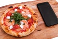 Pizza, Italian food delivery, call or order online on mobile, cellular, smart phone. Pizza and mobile phone on a wooden background Royalty Free Stock Photo