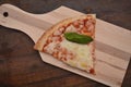 Pizza italian piece on wood tabble with tomato mozzarella cheese basil