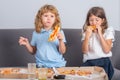 Pizza and kids, slices pizza in kids hand. Children girl and boy eating tasty fast food pizza with cheese. Pizza home Royalty Free Stock Photo