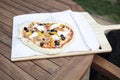 Pizza on spatulal ready to be placed in an outdoor oven Royalty Free Stock Photo