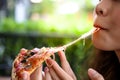 Pizza look so yummy or delicious food. Charming beautiful asia woman is eating pepperoni pizza and sticky mozzarella cheese. Royalty Free Stock Photo