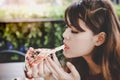 Pizza look so yummy or delicious food. Charming beautiful asian woman is eating pepperoni pizza and sticky mozzarella cheese. Royalty Free Stock Photo