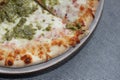 Pizza Magherita with green pesto on it and a nice and crispy edge with cheese