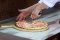 Pizza maker cutting pizza with a pizza knife