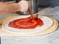 Pizza Maker puts on the sauce Royalty Free Stock Photo