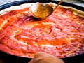 Pizza Maker puts on the sauce Royalty Free Stock Photo