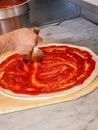 Pizza Maker puts on the sauce Royalty Free Stock Photo