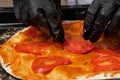 The pizza maker puts tomato slices on the pizza Royalty Free Stock Photo