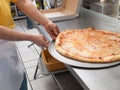 Pizza Maker removes a Fresh Pizza from the oven Royalty Free Stock Photo