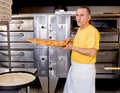 Pizza Maker removes a Fresh Pizza from the oven Royalty Free Stock Photo