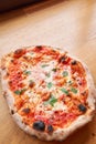 Pizza Margarita. Baked tasty margherita pizza in Traditional wood oven in Neapolitan restaurant, Italy. Royalty Free Stock Photo