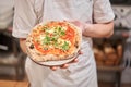 Pizza Margarita. Baked tasty margherita pizza in Traditional wood oven in Neapolitan restaurant, Italy. Royalty Free Stock Photo