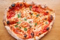 Pizza Margarita. Baked tasty margherita pizza in Traditional wood oven in Neapolitan restaurant, Italy. Royalty Free Stock Photo