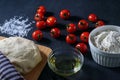 Pizza. Margarita pizza ingredients and raw dough on a black background Royalty Free Stock Photo