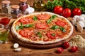 Pizza margarita with tomato sauce, fresh mozzarella, parmesan and basil on the wooden rusty background Royalty Free Stock Photo