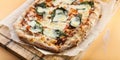 Pizza Margherita with basil on a cutting board. Close-up. Horizontal shot. Orange background